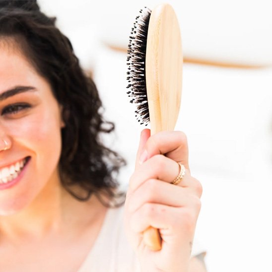 Brosse poil de sanglier- femme qui sourit avec sa brosse